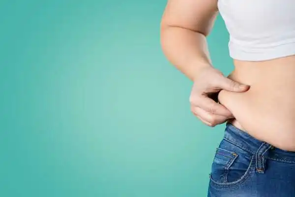 Image of woman pinching her love handles to show weight gain Warfield